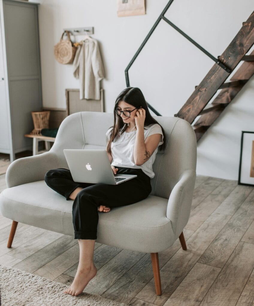 Woman with laptop on sofa at home